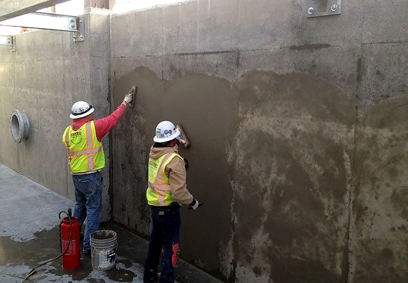 PCR Solutions crew smoothing a concrete wall on site