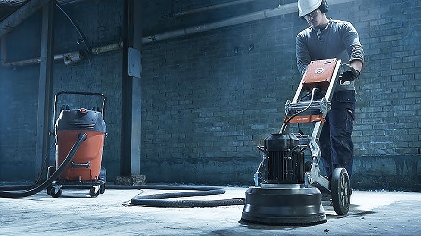Technician operating a floor grinder to level a concrete slab