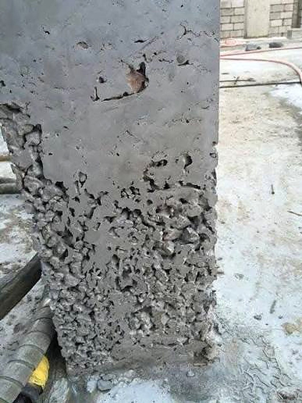 Concrete column with severe honeycombing exposing the rebar cage