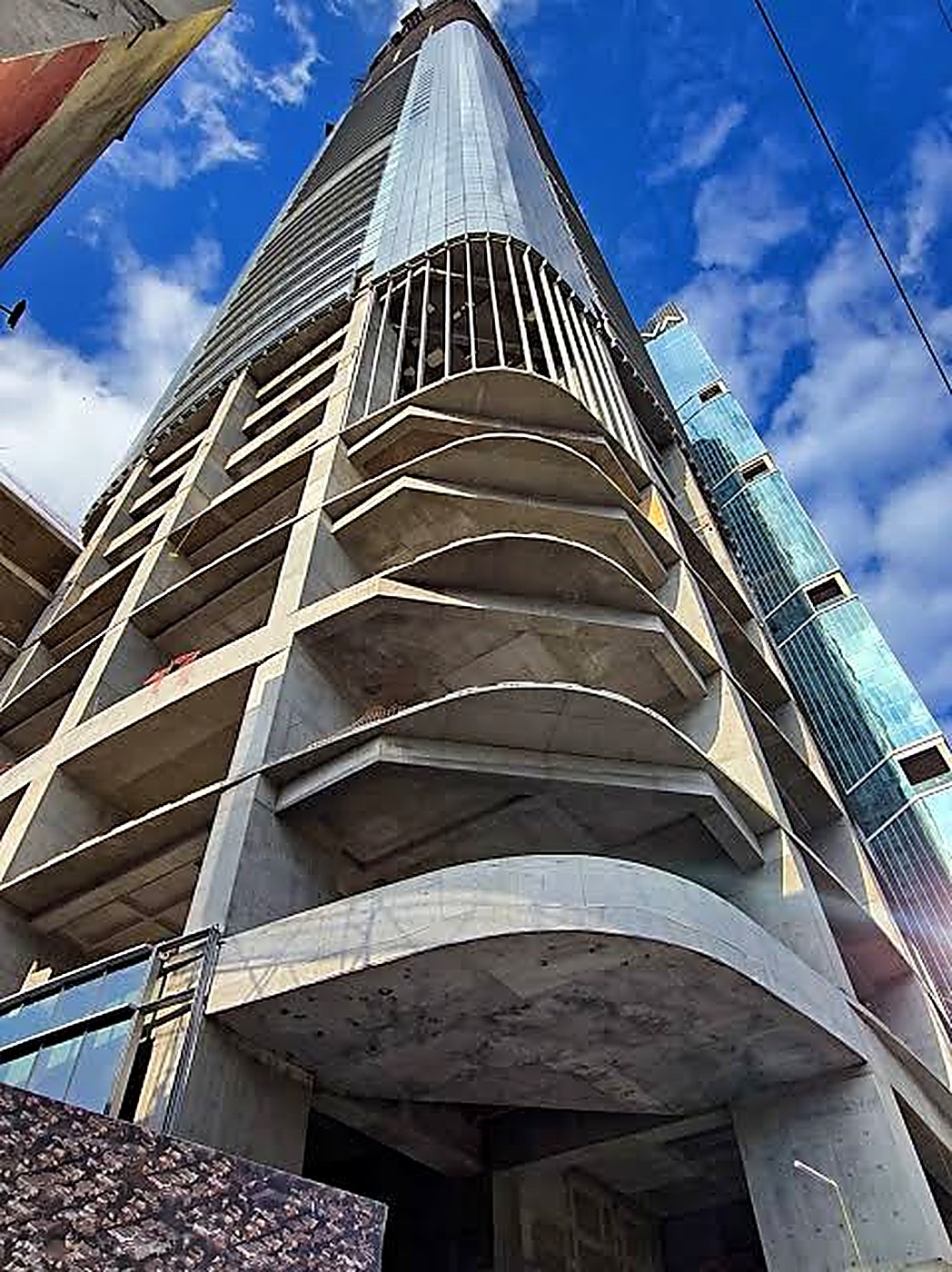 High-rise concrete structure under construction with open window and door openings