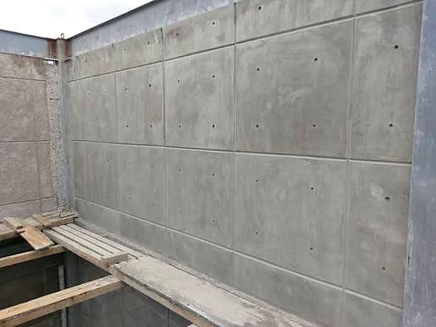 Formed concrete wall with clean panel joints and tie-hole pattern